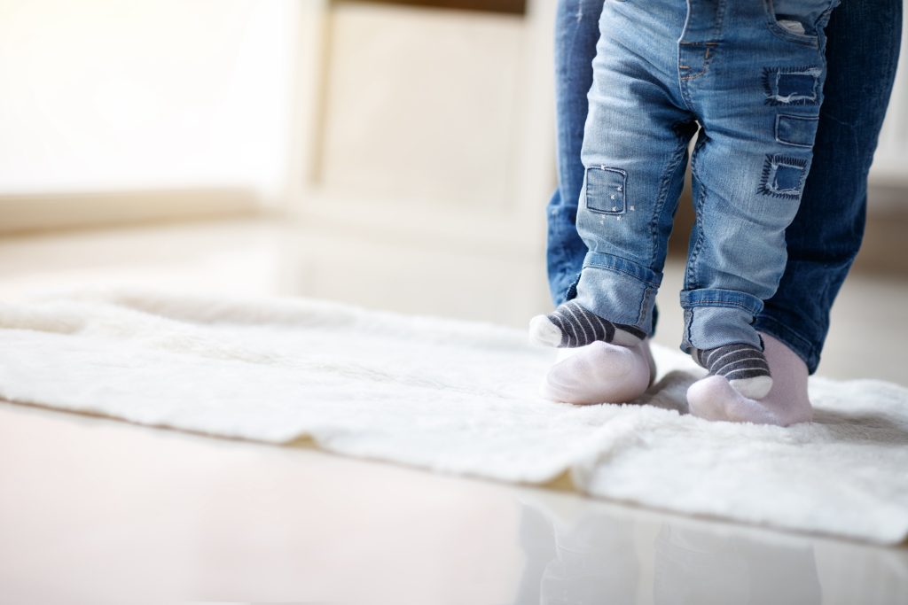 Young boy standing on dad's feet