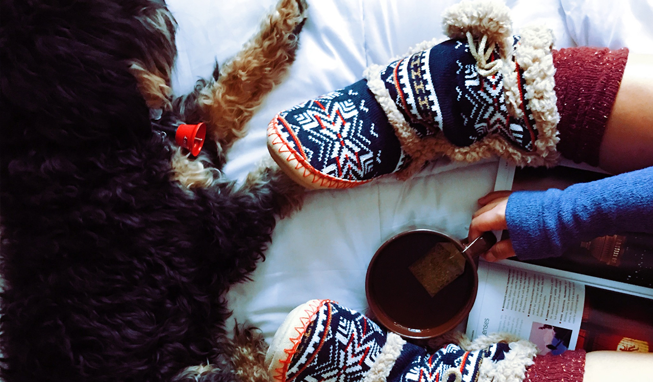 Person with Raynaud’s keeping feet warm with thick socks and slippers