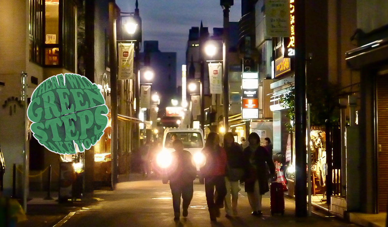 An image of Komachi Street at night, with the Green Steps sticker (middle, left)